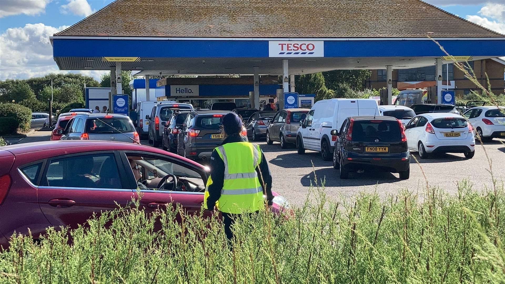 Staff try to marshal motorists queueing for fuel at Tesco, Sheerness