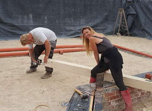 Heidi helps with the wooden posts - tarpaulin on the rear walls acts as a membrane to stop damp seeping inside