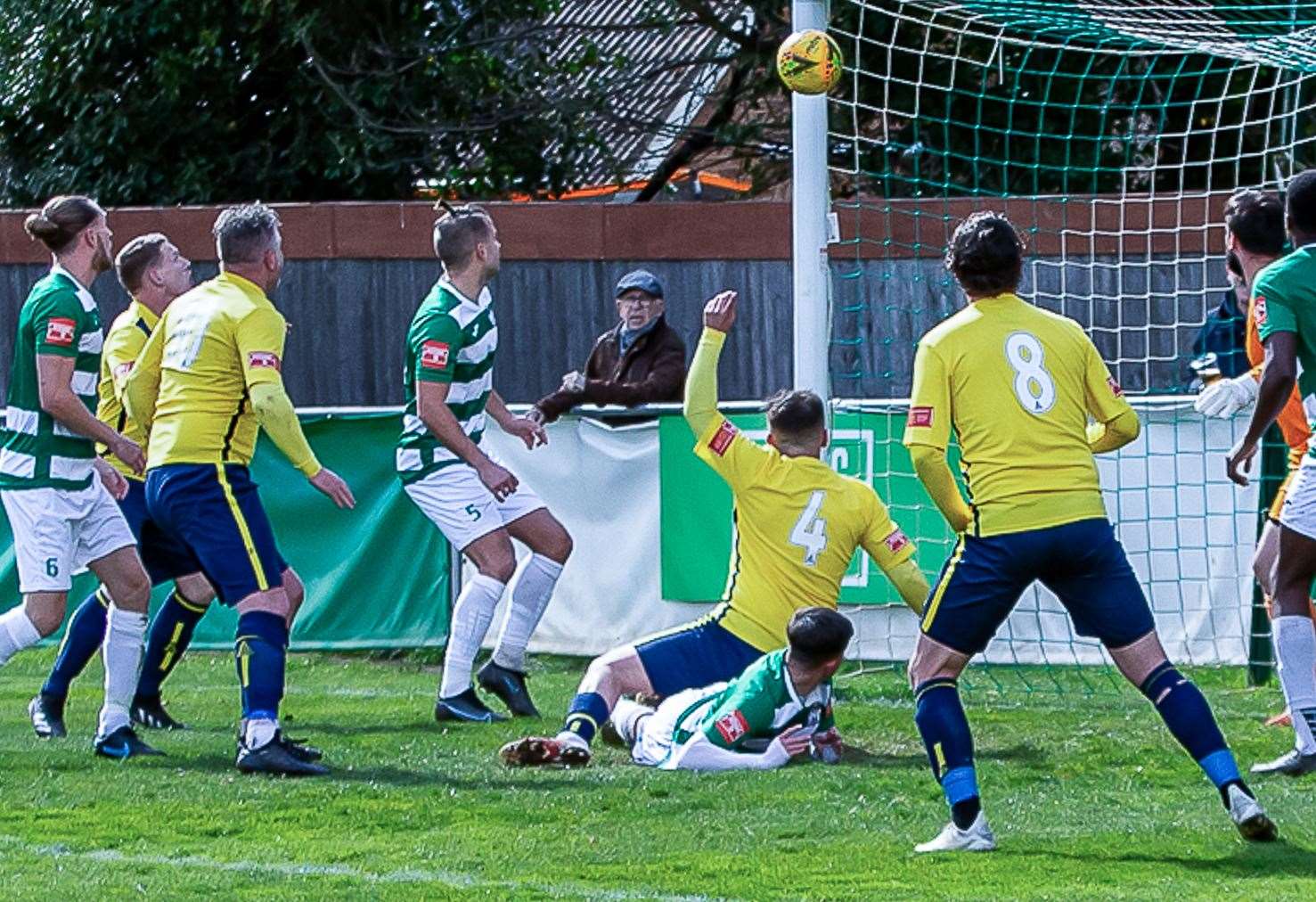 George Monger (number four) bundles the ball home during Whitstable's 1-1 draw at Corinthian. Picture: Les Biggs