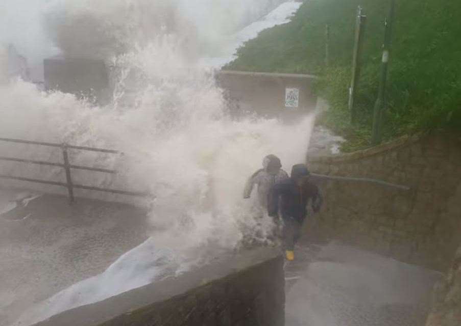 Another wave chases the boys up some steps on the promenade