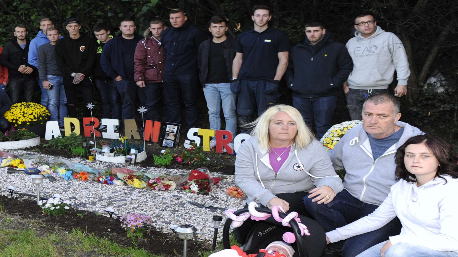 Loved ones of Adrian Stroud gather at the roadside memorial