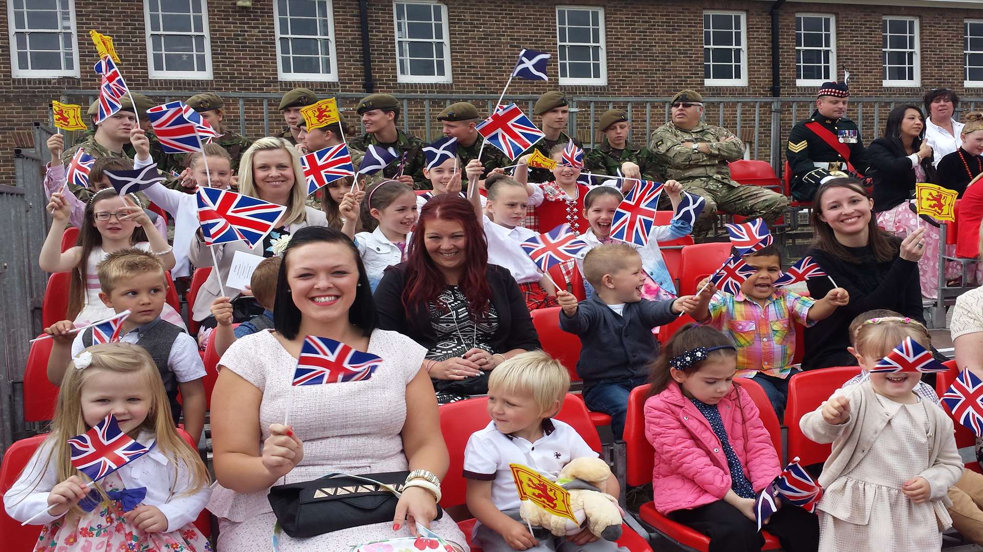 Flag-waving children await the arrival of the Queen