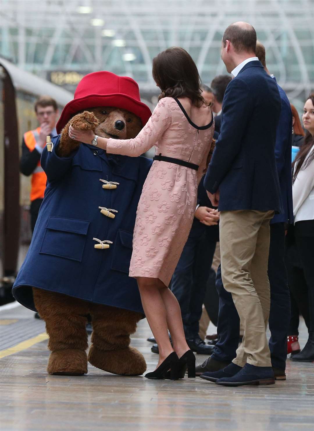 The Duke of Cambridge watches as his wife the Duchess of Cambridge dances with a costumed figure of Paddington bear (Jonathan Brady/PA)