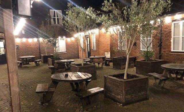 The courtyard area at the rear has half a dozen round picnic tables and at least as many good-sized olive trees