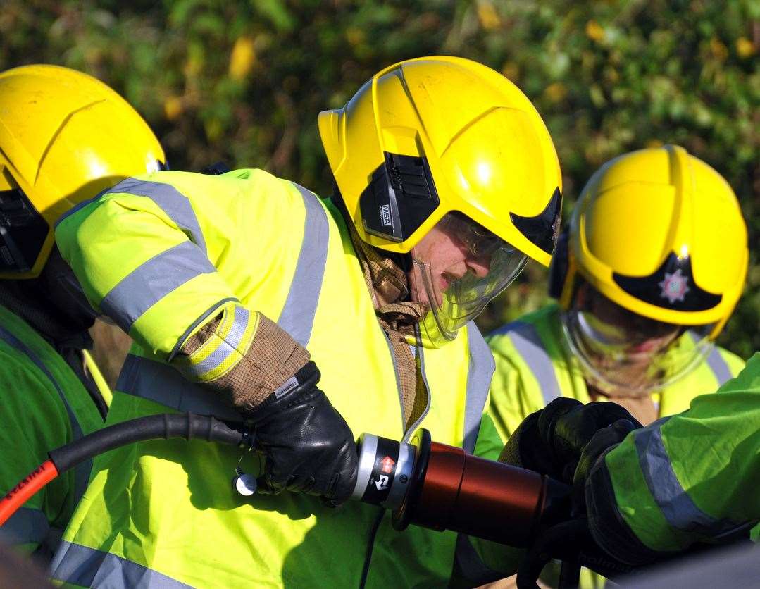 Fire crews have been seen cutting a person out of a car. Stock image