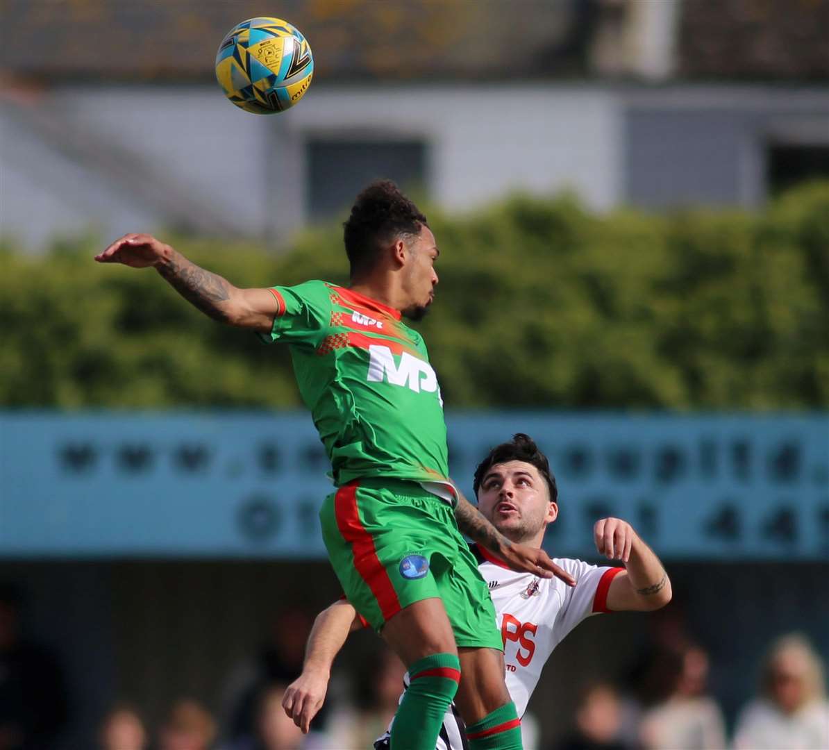 Troy Howard, of Lydd, jumps high as Deal defender Jack Penny pays close attention. Picture: Paul Willmott