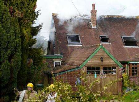 Firefighters at the scene of the house fire in Etchinghill. Picture: Max Hess