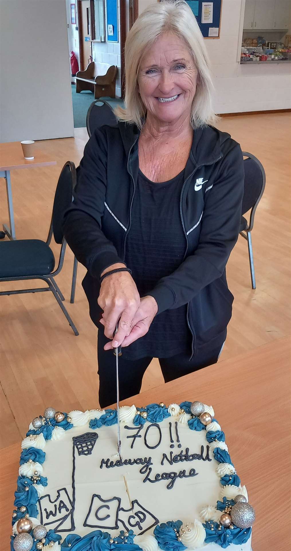 Life president Janet Waddington cuts the celebratory cake. Her mum, Pam Woolmer, founded the league