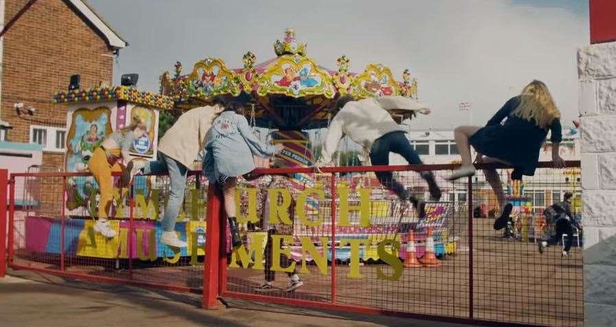 The band are seen 'breaking into' the theme park