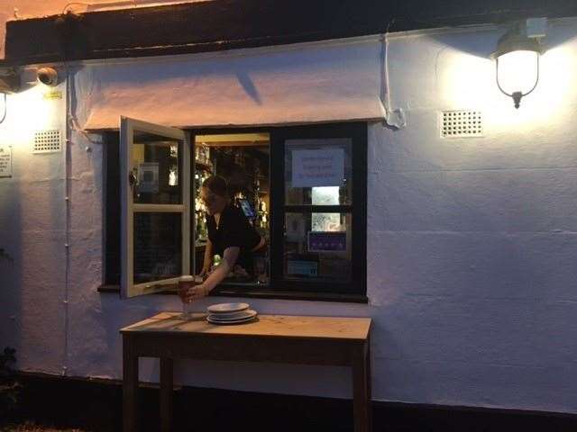 An open window at the front of the pub had a table outside so the barmaid could offer garden service to anyone who wants it