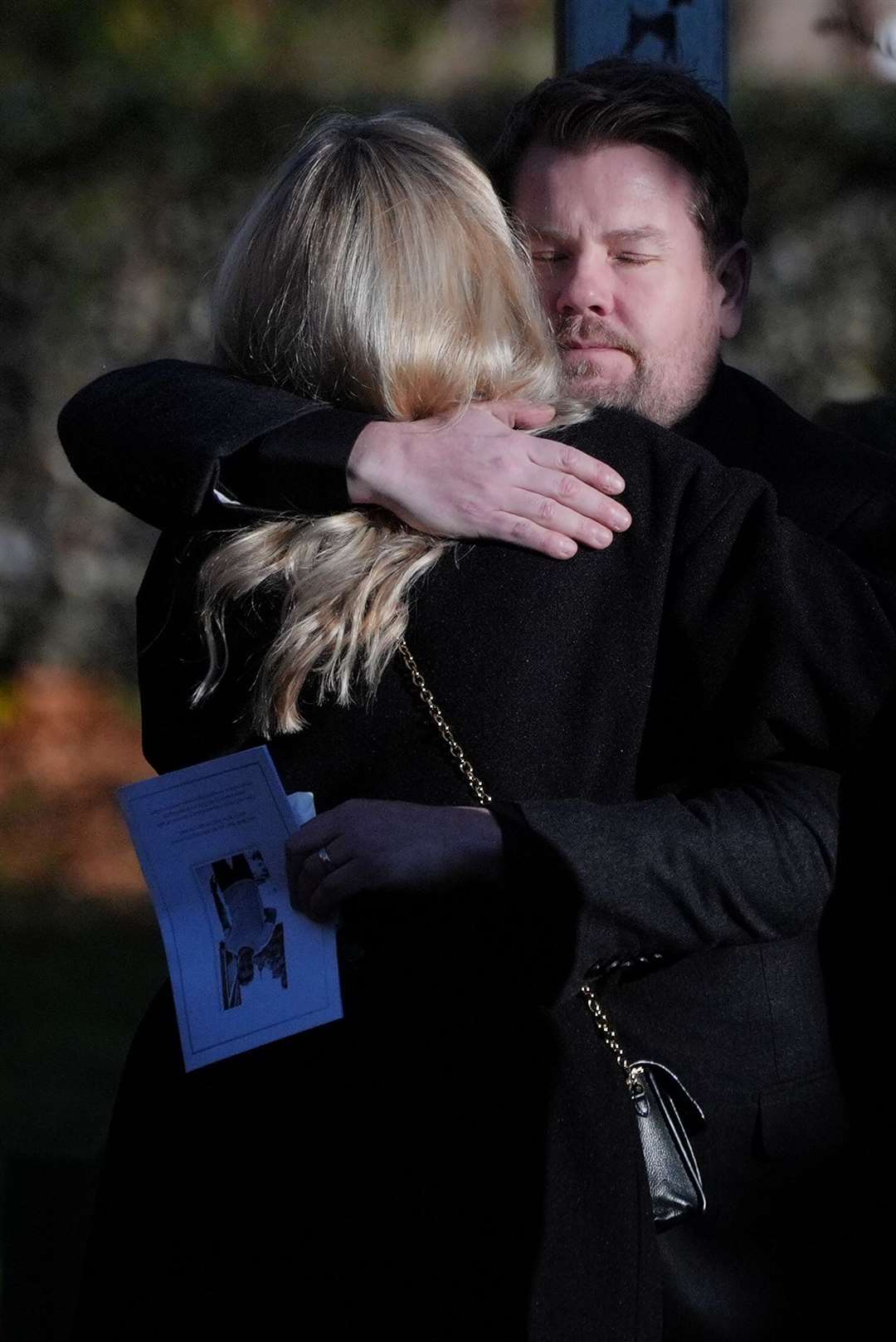 TV star James Corden hugs another guest after the funeral service (Jonathan Brady/PA)