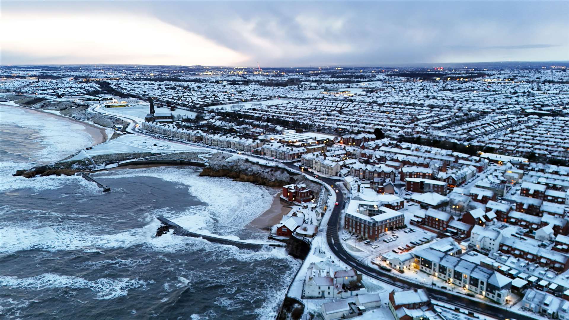 Houses, cars and roads were covered with snow this morning in Cullercoats Bay in North Tyneside (Owen Humphreys/PA)