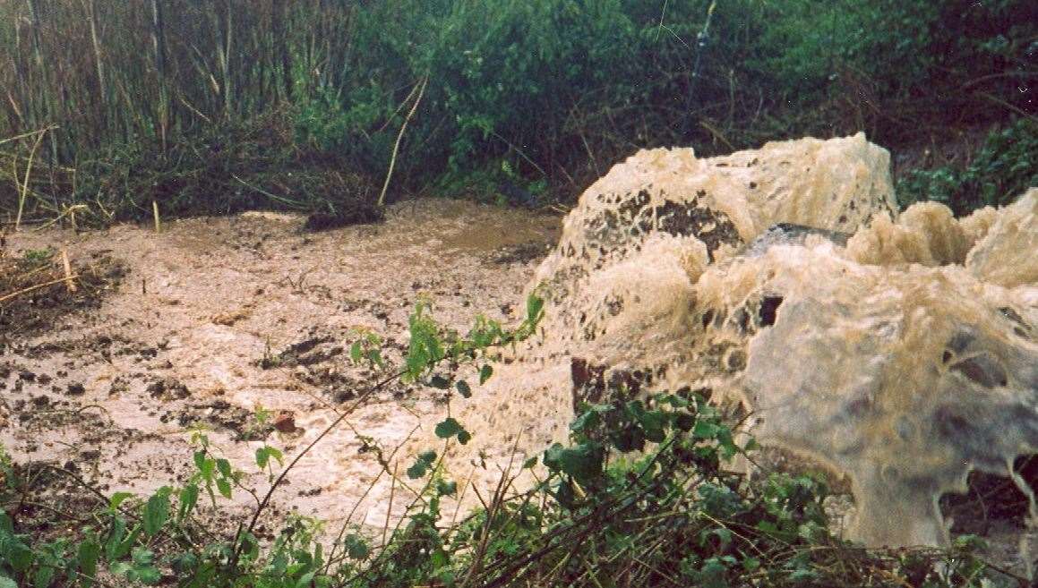 Sewage gushes out of a drain. Stock picture