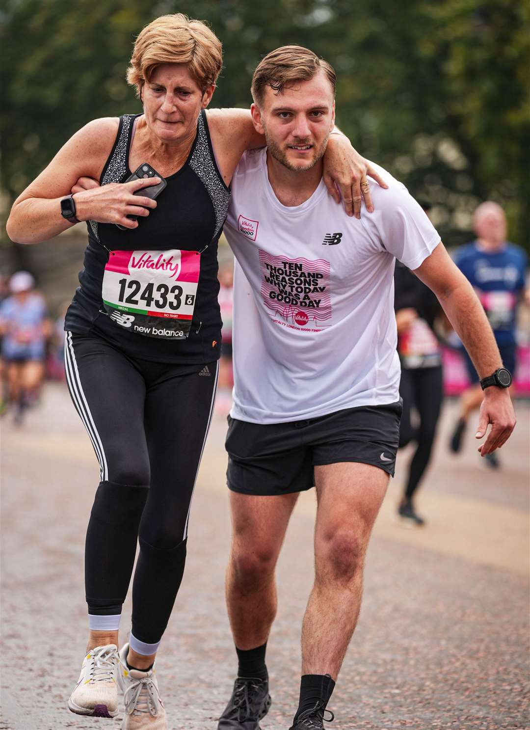 Nicky Ripley being helped over the finish line by fellow runner Ryan Burt-Allen. Picture: Sportograf