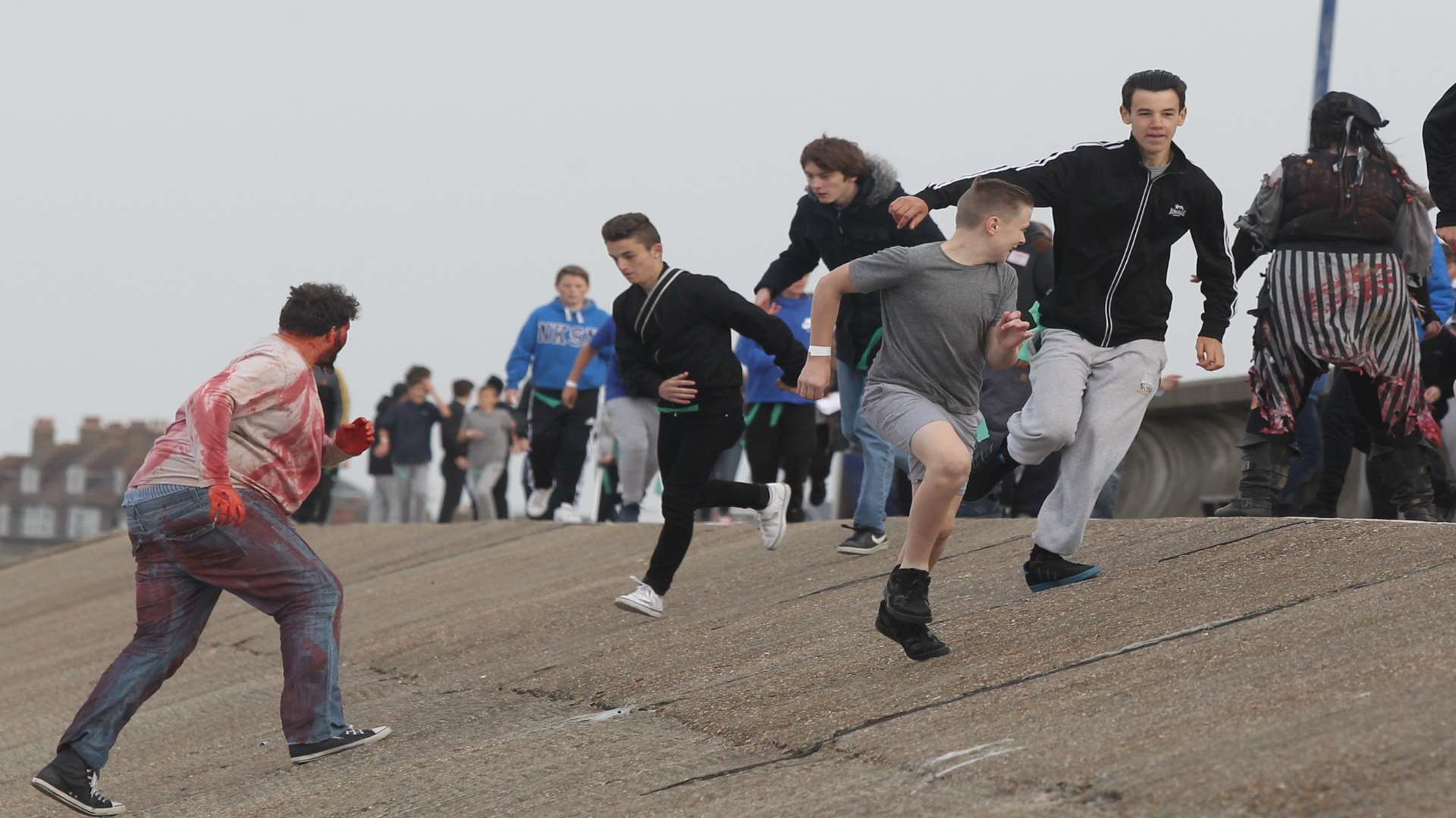 Zombies chase after "civilians" during a zombie event along the beach in Sheerness.