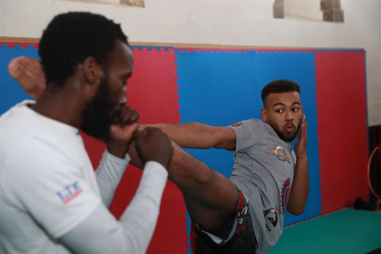 Kayne, 19, high kicks his head coach Chris Garnett. Pictures: John Westhrop