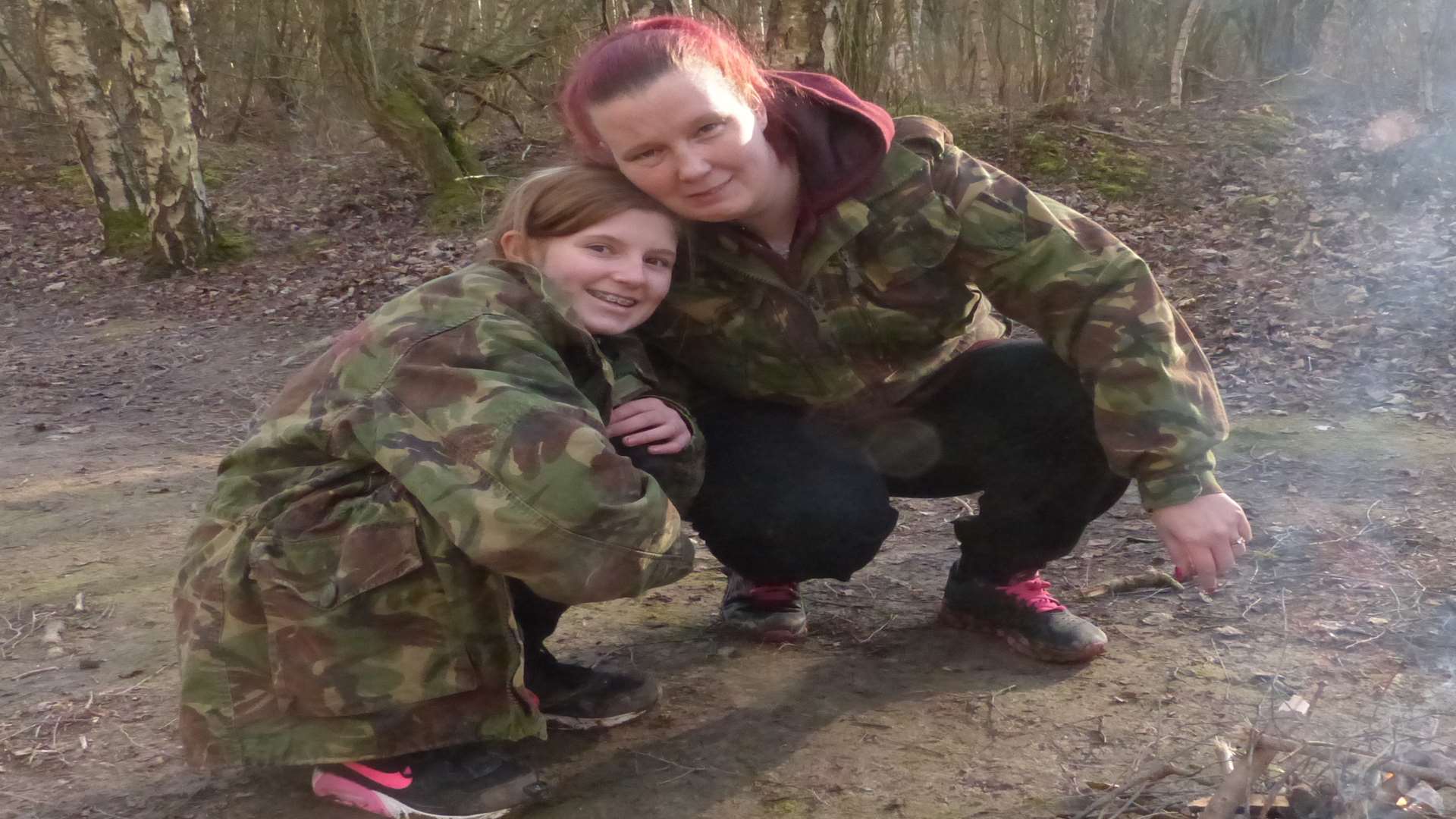 Look what they made - mother and daughter sharing a moment of celebration together as their fire starts to catch.