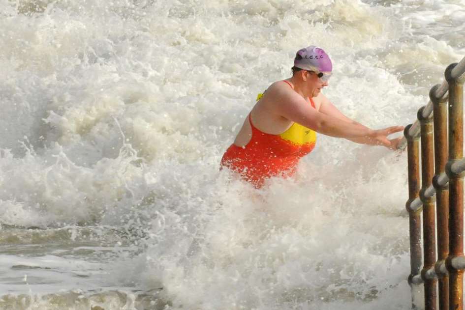 Clutching onto a rail, this woman steadies herself on Folkestone seafront