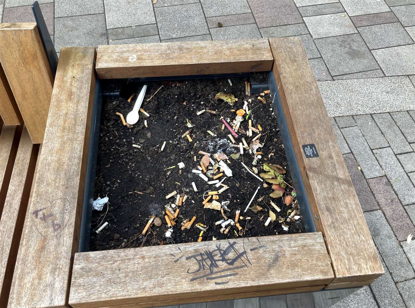 Dozens of cigarette buts in one of the planters this week