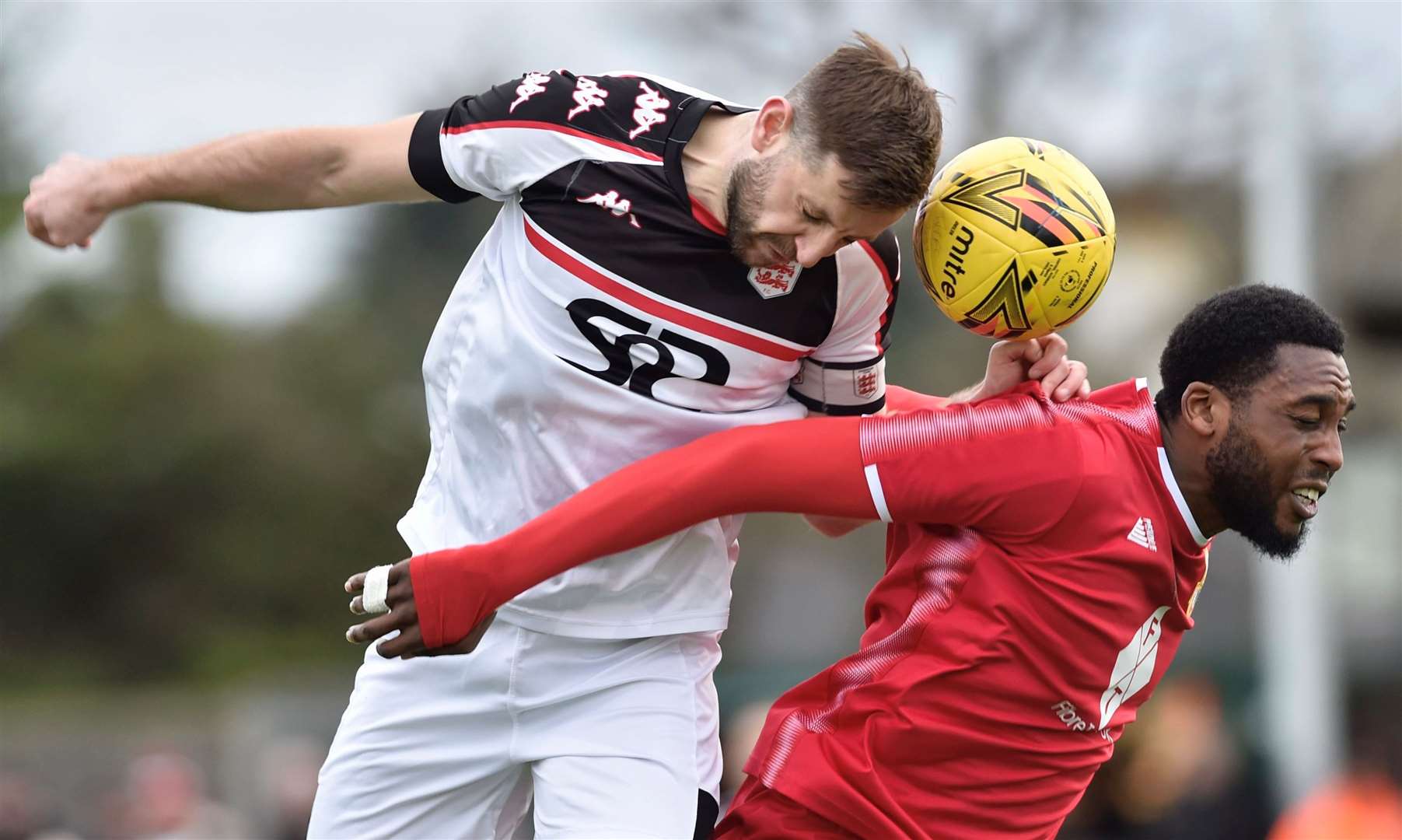 Faversham captain Connor Essam challenges in the air with Whitstable striker Emmanuel Oloyede. Picture: Ian Scammell