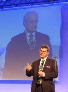 Kent Reliance Building Society chairman Malcolm McCaig is watched on the big screen by chief executive Mike Lazenby