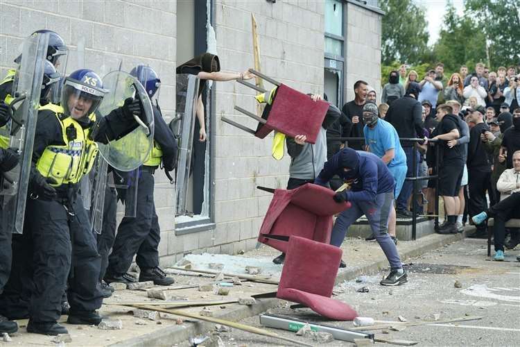 A chair is thrown at police officers outside the Holiday Inn Express in Rotherham (Danny Lawson/PA)